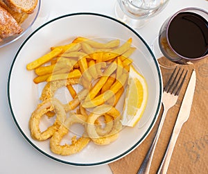 Deep-fried coated squid rings served with lemon and fries