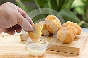 Deep fried dough bun dip in sweetened condensed milk