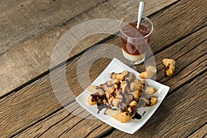 Deep-fried dough stick and coffee on wooden to creative