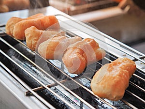 Deep-fried dough sticks Youtiao or pathongko roasted on the grill charcoal.