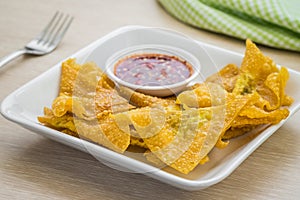 Deep fried dumplings and dipping sauce on plate
