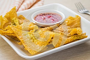 Deep fried dumplings and dipping sauce on plate