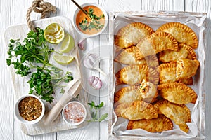 Deep fried empanadas in a wooden box