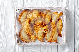 Deep fried empanadas in a wooden box