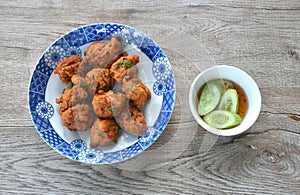 deep fried fish patty on plate with slice cucumber dipping sweet chili sauce