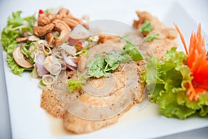 Deep fried fish serve with spicy salad and vegetab