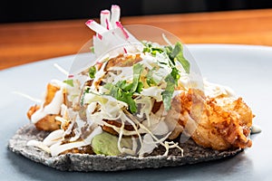 Deep fried fish taco in a black corn tortilla