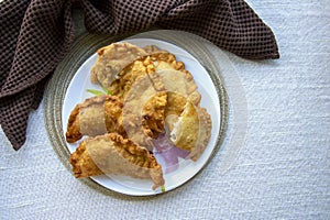 Deep-fried golden chebureks or dumplings are laid out on a plate