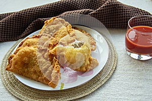 Deep-fried golden chebureks or dumplings are laid out on a plate