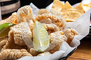 Pork Rinds also called chicharron or chicharrones and tortilla chips with salsa