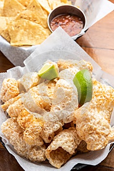 Pork Rinds also called chicharron or chicharrones and tortilla chips with salsa photo