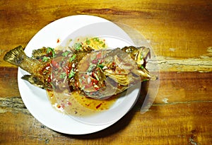 Deep fried red banded grouper fish dressing sweet chili sauce on plate