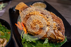 Deep Fried Sea Bass with Deep Fried Garlic on Black Plate