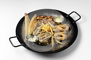 Deep fried set made from french fries, onion rings, big and small fried fish served in a wok over white background.