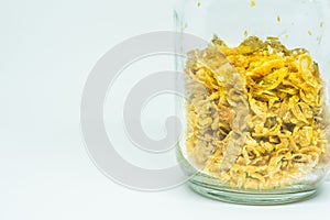 Deep-fried shallots on clear glass jar, isolated on white background.