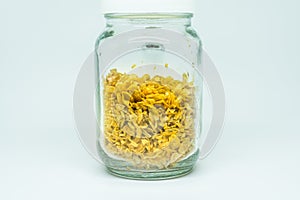 Deep-fried shallots on clear glass jar, isolated on white background.