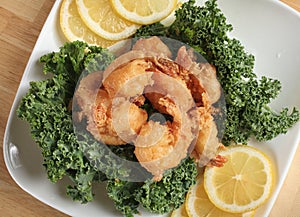 Deep fried shrimp on garnished plate with lemon