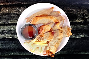 Deep fried spring roll,and frence fries sreved with tomato souce and chili sauce.