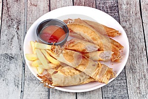 Deep fried spring roll,and frence fries sreved with tomato souce and chili sauce.