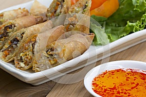 Deep fried spring rolls, Por Pieer Tod or Fried spring rolls Thai Spring Roll on white dish on wooden table,Thai and Chinese