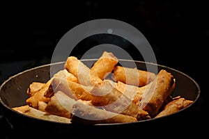 deep fried spring rolls surve on the pan in dark background