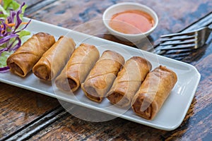 Deep fried spring rolls and vegetables on plate