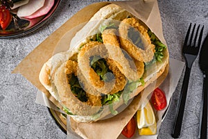 Deep fried squid in bread with greens on the side. Squid sandwich