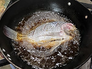Deep fried whole fish with plenty oil.