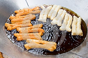 Deep frying bread stick or popularly known as You Tiao, a popular Chinese delicacy photo