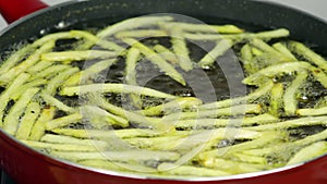 Deep frying French Fries in a red skillet