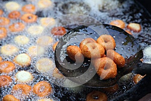 Deep frying medu vada in the pan. Medu Vada is a savoury snack from South India, very common street food in the India.