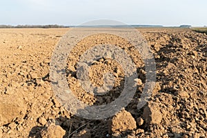 Deep furrows in the ground after working the tractor with the plow. Plowing the land. treatment of the top layer of soil to