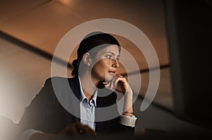 Deep in the get it done zone. a young businesswoman working online during a late night in a modern office.