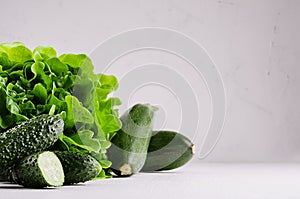 Deep green different vegetables on soft white wood table with copy space.