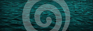 Deep green water background. Light ripples and waves on the water surface. Beautiful green background with copy space for design.