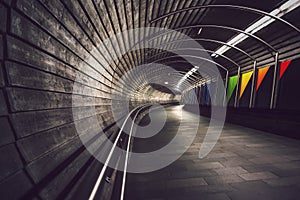 Deep perspective into dark, winding underground tunnel photo