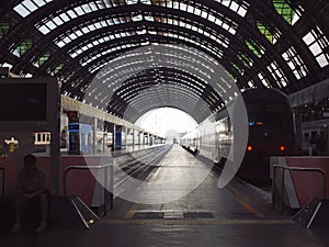 Deep perspective of rails and train at Milan central station.