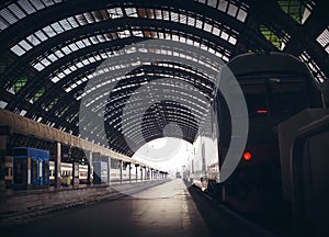 Deep perspective of rails and a train at Milan central station.