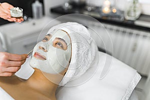 Deep purifying procedure at SPA. Portrait of beautiful positive smiling Asian woman in her 20s with white towel on her