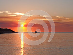 Deep red sunset and sail boat at Fannie bay