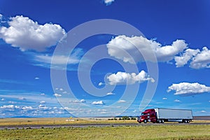 Deep red truck moving along a highway