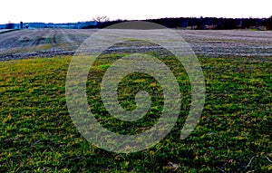 Deep, Rich Green Grass Set Against Rolling Farmland Creates Dramatic Sunset Vista