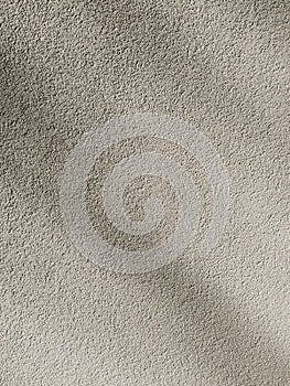 Deep shadows on a plaster cement wall. Abstract beige background, grunge concrete texture. Minimal vertical backdrop.