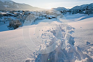 Deep snow track through winter landscape during sunset in alpine village  Wildermieming  Tirol  Austria