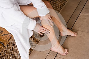 Deep vein thrombosis and varicose of woman. Girl touching her legs and looking at veins. Sclerotherapy procedure at