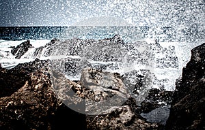 Deep view over lava rocks with breaking of waves