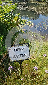 Deep water danger sign on waters edge.