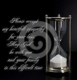 Deepest condolence white sand timer on black background with text