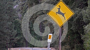 Deer crossing yellow road sign, California USA. Wild animal xing, traffic safety