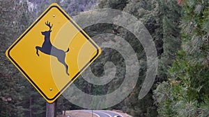 Deer crossing yellow road sign, California USA. Wild animal xing, traffic safety